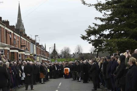 The coffin of Martin McGuinness is surrounded by mourners during his funeral in Londonderry, Northern Ireland, March 23, 2017. REUTERS/Clodagh Kilcoyne