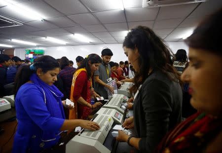 Workers laminate voters' identity cards as they prepare for the upcoming local election of municipalities and villages representatives at the election commission in Kathmandu, Nepal April 23, 2017. REUTERS/Navesh Chitrakar/Files