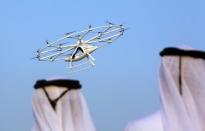 Men look at the flying taxi in Dubai, United Arab Emirates September 25, 2017. REUTERS/Satish Kumar