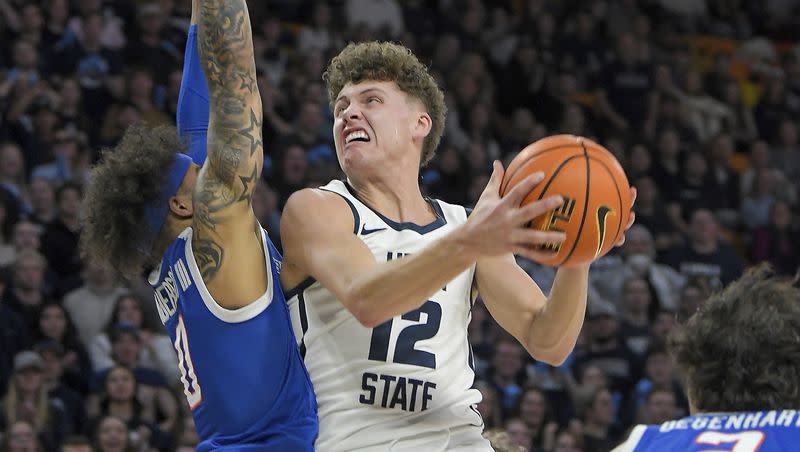 Utah State guard Mason Falslev (12) looks for a shot as Boise State guard Roddie Anderson III (0) defends during the first half of an NCAA college basketball game Saturday, Feb. 10, 2024, in Logan, Utah.