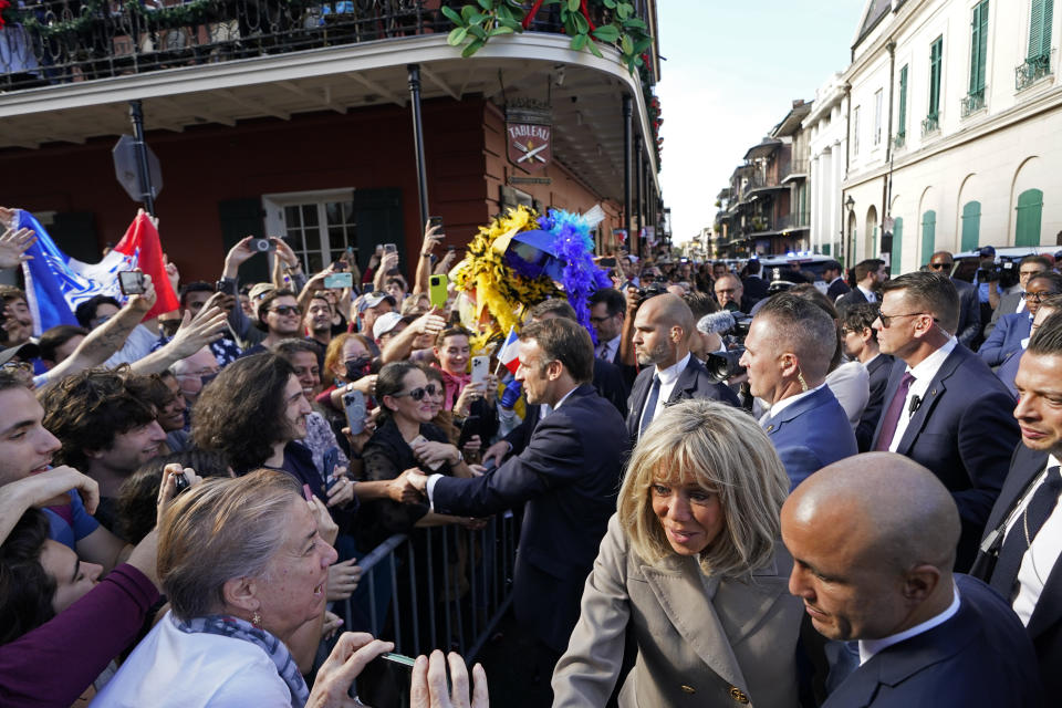 French President Emmanuel Macron and his wife Brigitte Macron greet the crowd as they arrive in New Orleans, Friday, Dec. 2, 2022. (AP Photo/Gerald Herbert)