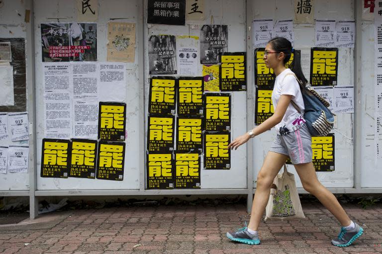 A student walks past posters (black and yellow) calling for strikes at the Chinese University of Hong Kong on September 22, 2014