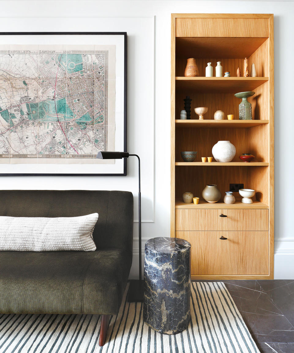 Stylish artwork, wooden shelving unit, large map artwork, bench and floor lamp