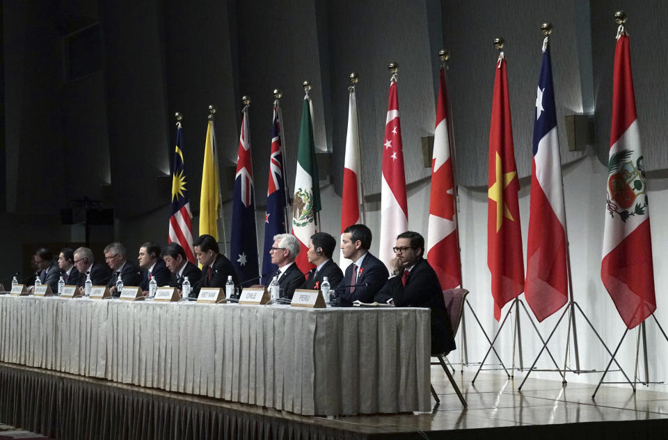 Toshimitsu Motegi, Japan's minister of economy, trade, and industry, sits with other ministers and delegates of a Pacific Rim trade bloc, attend a joint press conference after a session of the Comprehensive and Progressive Trans-Pacific Partnership (CPTPP) in Tokyo Saturday, Jan. 19, 2019. Trade ministers of a Pacific Rim trade bloc are meeting in Tokyo, gearing up to roll out and expand the market-opening initiative. (AP Photo/Eugene Hoshiko)