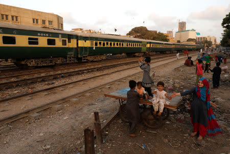 Children play as a passenger train passes along a neighbourhood in Karachi, Pakistan September 19, 2018. REUTERS/Akhtar Soomro