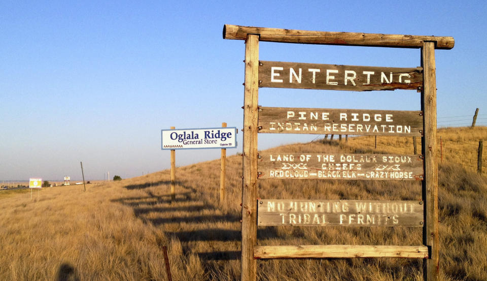 FILE - A sign hangs outside the entrance to the Pine Ridge Indian Reservation in South Dakota, home to the Oglala Sioux tribe, Sept. 9, 2012. Tribal leaders in South Dakota have denounced Republican Gov. Kristi Noem’s comments in which she accused them of keeping her from helping impoverished children on reservations and benefiting from Mexican drug cartels she’s said are operating on tribal lands. (AP Photo/Kristi Eaton, File)