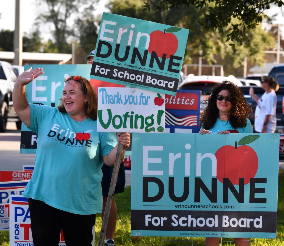 On Election Day 2022, school board candidate Erin Dunne waves at voters at Kiwanis Island on Merritt Island.