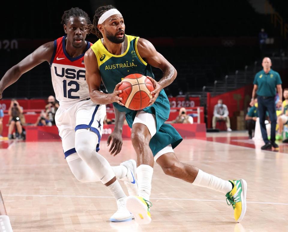 Patty Mills of Team Australia drives to the basket against Jrue Holiday of Team USA (Getty)