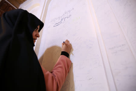 An Iranian pilgrim woman writes her memories in the former home of the late Ayatollah Ruhollah Khomeini, in Najaf, Iraq February 9, 2019. Picture taken February 9, 2019. REUTERS/Alaa al-Marjani