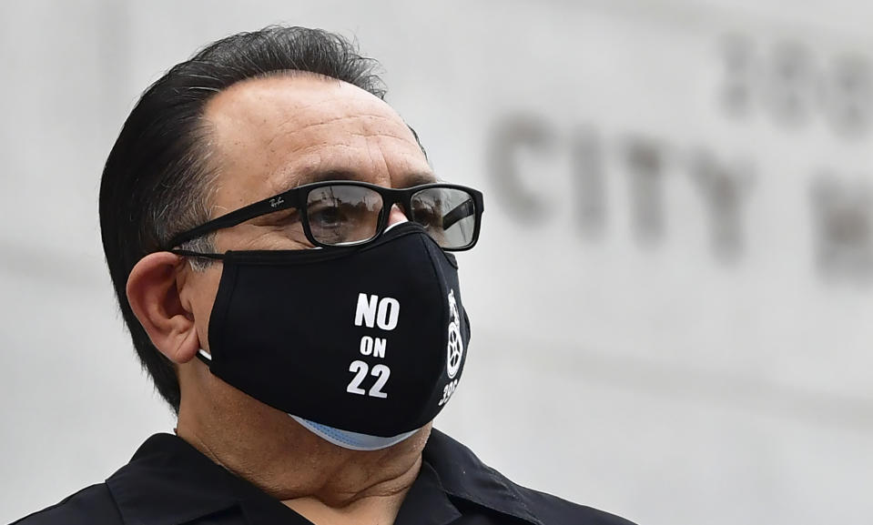 A protester stands in front of City Hall in Los Angeles on October 22, 2020 where elected leaders hold a conference urging voters to reject on the November 3 election, Proposition 22, that would classify app-based drivers as independent contractors and not employees or agents. (Photo by Frederic J. BROWN / AFP) (Photo by FREDERIC J. BROWN/AFP via Getty Images)