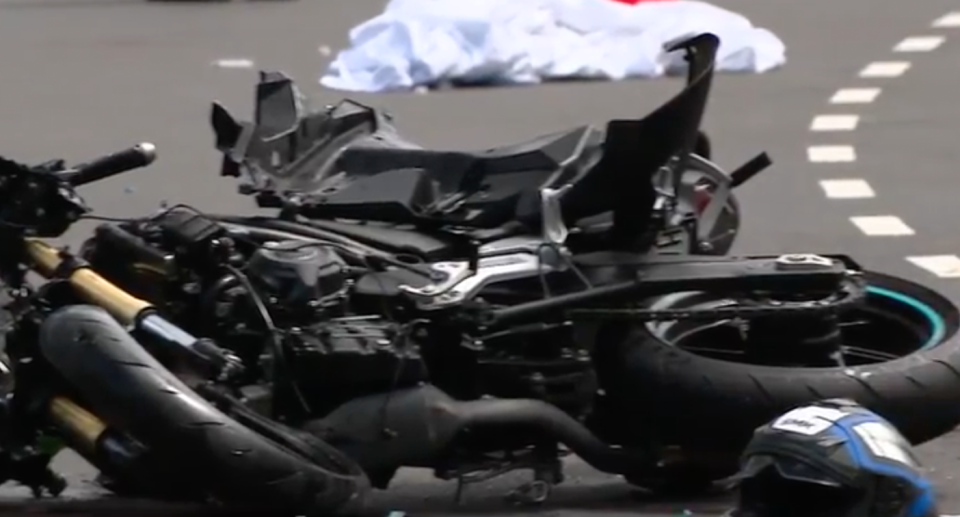 The damaged motorbike lying on Epping Road beside the rider's helmet. 