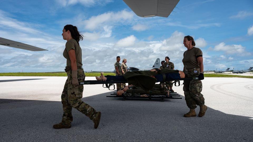 U.S. Air Force and Royal Canadian Air Force aeromedical evacuation personnel transport manikins to a static Super Hercules aircraft during the exercise Mobility Guardian at Andersen Air Force Base, Guam, on July 10, 2023. (Staff Sgt. Taylor Crul/U.S. Air Force)