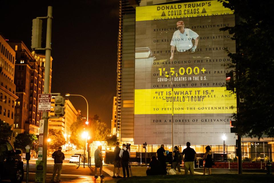 A Democratic National Committee slideshow criticizing President Donald Trump's handling of the coronavirus pandemic is projected onto the side of the former Newseum, about six city blocks away from the Mellon Auditorium, where a portion of the first day of the Republican National Convention took place in Washington, Aug. 24, 2020.