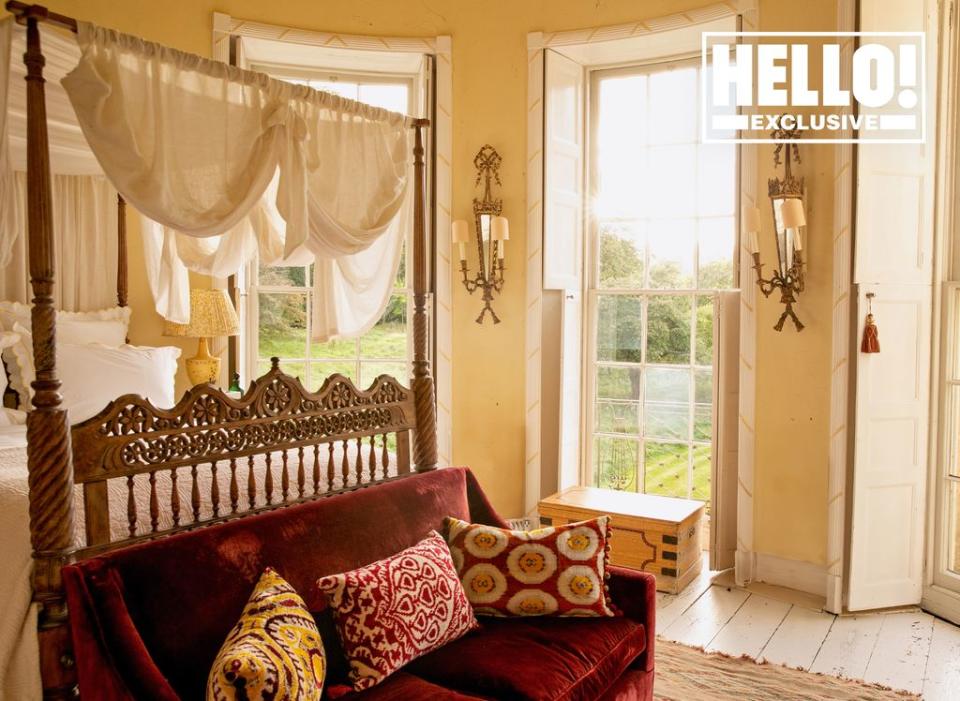 Conran family home bedroom with four poster bed and red velvet sofa