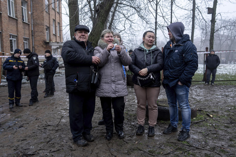 A woman cries in front of the building which was destroyed by a Russian attack in Kryvyi Rih, Ukraine, Friday, Dec. 16, 2022. Russian forces launched at least 60 missiles across Ukraine on Friday, officials said, reporting explosions in at least four cities, including Kyiv. At least two people were killed by a strike on a residential building in central Ukraine, where a hunt was on for survivors. (AP Photo/Evgeniy Maloletka)