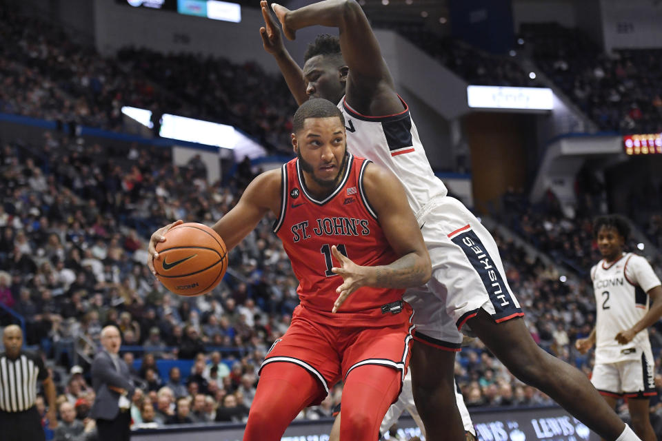 St. John's Joel Soriano, left, dribbles as UConn's Adama Sanogo defends in the first half of an NCAA college basketball game, Sunday, Jan. 15, 2023, in Hartford, Conn. (AP Photo/Jessica Hill)