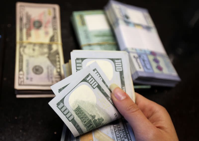 A woman counts U.S. dollar banknotes at a currency exchange shop in Beirut