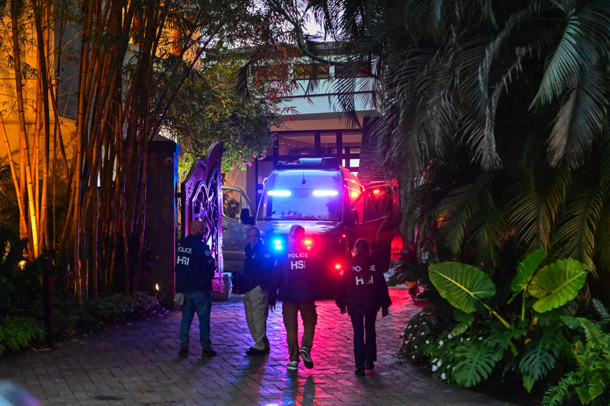 Four Homeland Security Investigation agents stand near the entrance of Combs’s Miami home.