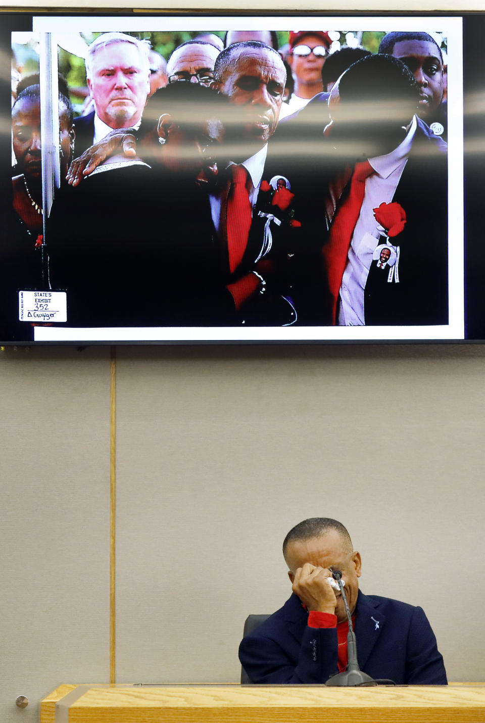 Bertrum Jean, father of Botham Jean, breaks down on the witness stand talking about the day he buried his son, pictured above, during the punishment phase of the trial of former Dallas police officer Amber Guyger, Wednesday, Oct. 2, 2019 at the Frank Crowley Courts Building in Dallas. Guyger was convicted of murder Tuesday in the killing of Botham Jean and faces a sentence that could range from five years to life in prison or be lowered to as little as two years if the jury decides the shooting was a crime of sudden passion. (Tom Fox/The Dallas Morning News via AP, Pool)