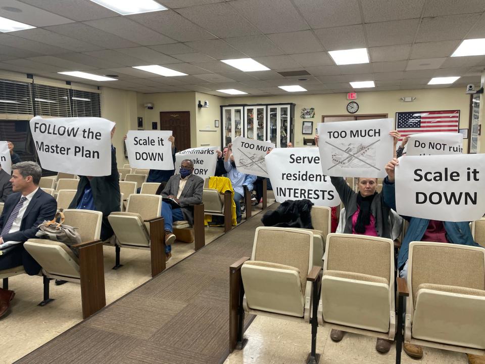 Residents hold up signs at the first meeting of the Montclair planning board to review the Lackawanna Plaza redevelopment plan. December 12, 2022.