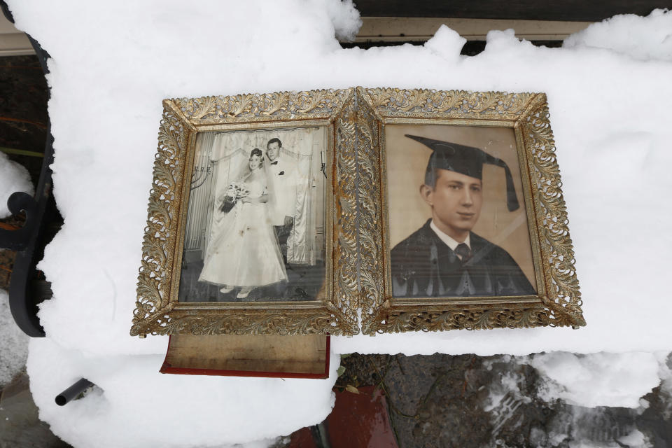 Photographs of Elliott Miller's wedding day and graduation lay on a snow covered bench as Jeanene Miller tries to dry out the pictures of her in-laws which were damaged during floods caused by Superstorm Sandy, Thursday, Nov. 8, 2012, in Point Pleasant, N.J.  The New York-New Jersey region woke up to wet snow and more power outages Thursday after the nor'easter pushed back efforts to recover from Superstorm Sandy, that left millions powerless and dozens dead last week. (AP Photo/Julio Cortez)