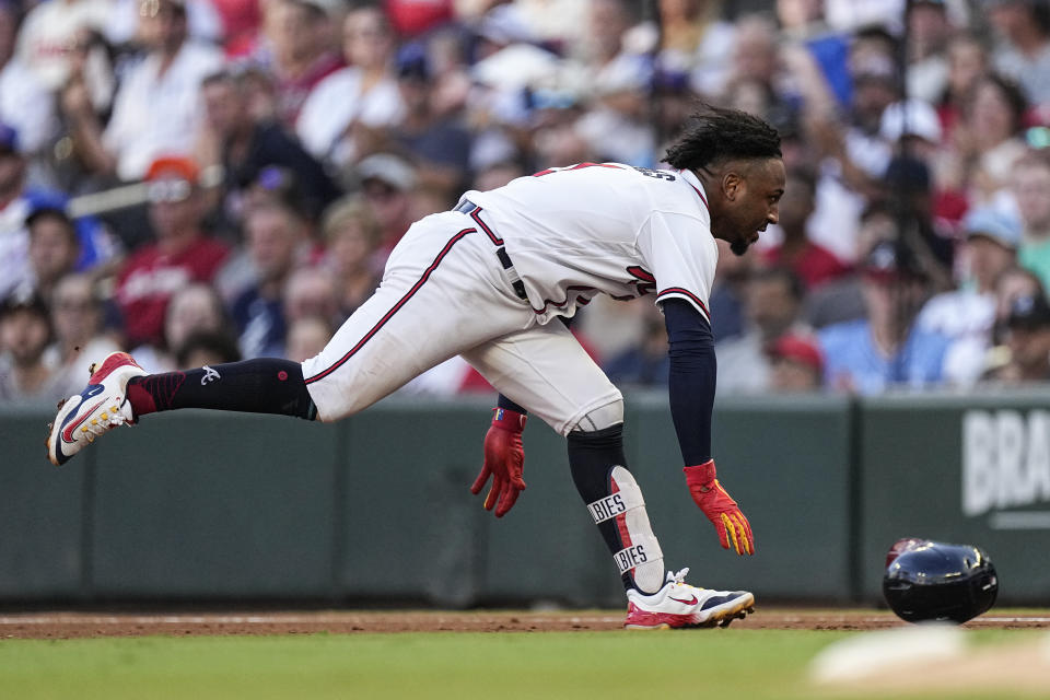 Atlanta Braves' Ozzie Albies dives back to first base after hitting a single in the first inning of a baseball game against the Los Angeles Angels Tuesday, Aug. 1, 2023, in Atlanta. (AP Photo/John Bazemore)