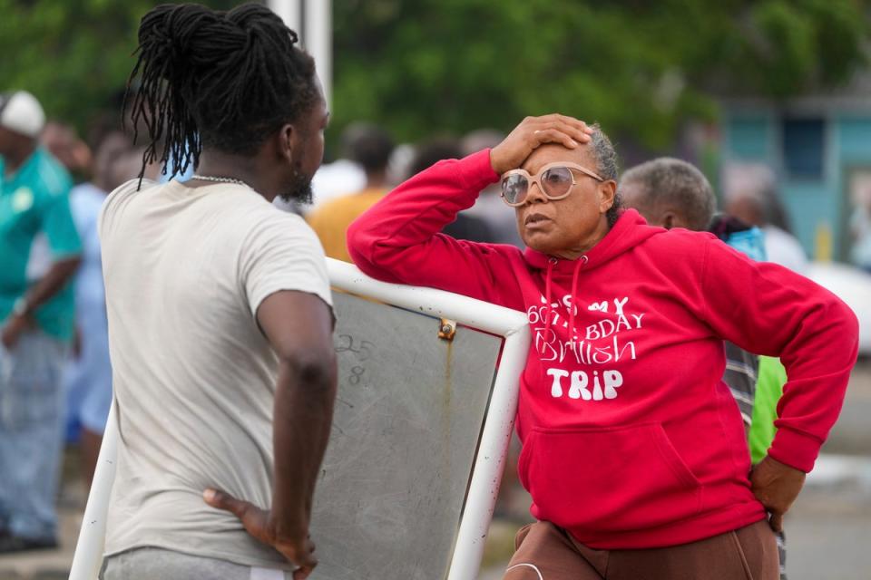 <p>Sylvia Small, right, waits for police approval to enter the pier to check her boat's damages due to Hurricane Beryl at the Bridgetown Fisheries in Barbados</p> (AP)