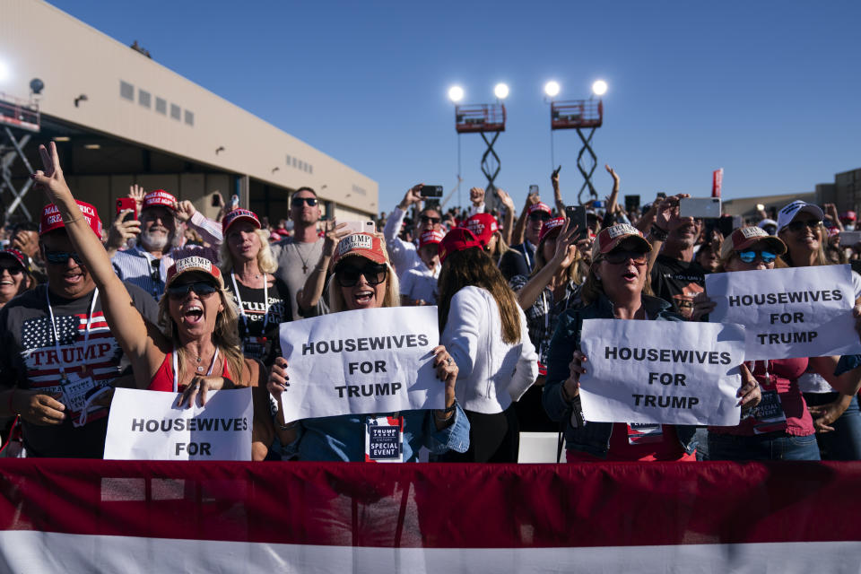 In this Oct. 28, 2020, photo, supporters of President Donald Trump listen to him speak during a campaign rally at Phoenix Goodyear Airport in Goodyear, Ariz. Trump is painting an apocalyptic portrait of American life if Democrat Joe Biden gets elected. The president claims that if the Democrat takes over, the suburbs wouldn’t be the suburbs anymore, the economy would slump into its worst depression ever and police departments would cease to exist.(AP Photo/Evan Vucci)