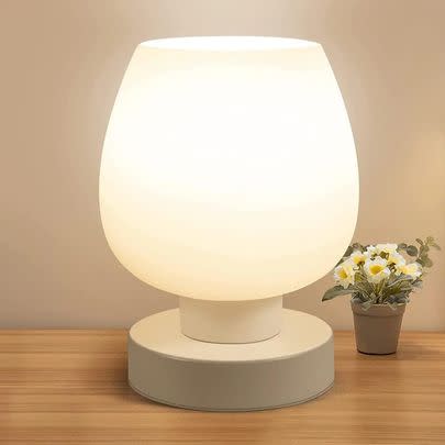 A touch-activated bedside light with a frosted glass globe