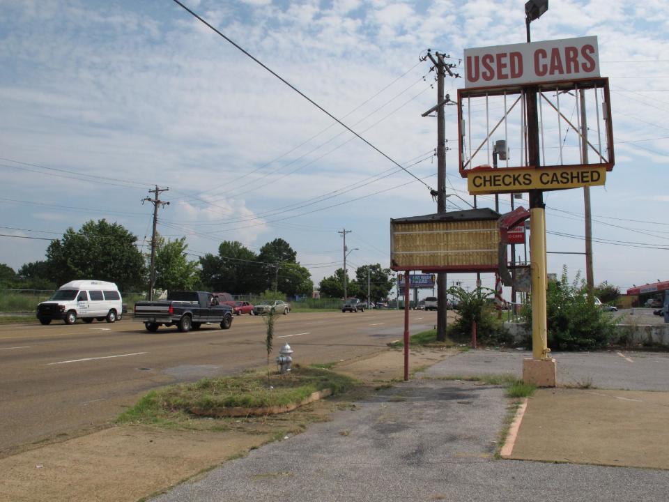 A dilapidated sign in front of a former used car dealership sits along Elvis Presley Blvd. on Tuesday, Aug. 6, 2013 in Memphis, Tenn. The boulevard, which runs right in front of Graceland, Presley's longtime Memphis home, is undergoing a $43 million infrastructure improvement project that officials hope will please tourists and improve the quality of life of the residents of the Whitehaven community. (AP Photo/Adrian Sainz)