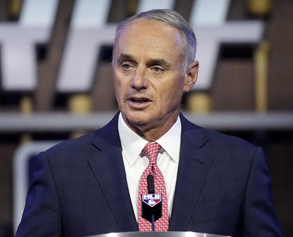 FILE - In this July 11, 2021, file photo, Major League Baseball Commissioner Rob Manfred kicks off the first round of the 2021 MLB baseball draft in Denver. As the World Series shifts to Atlanta, some TV viewers may be offended to see Braves fans still chopping and chanting. After teams in the NFL and Major League Baseball have dropped names viewed as offensive to Native Americans the last two years, the Braves chop on. The tomahawk chop has the support of baseball commissioner Rob Manfred. (AP Photo/David Zalubowski, File)