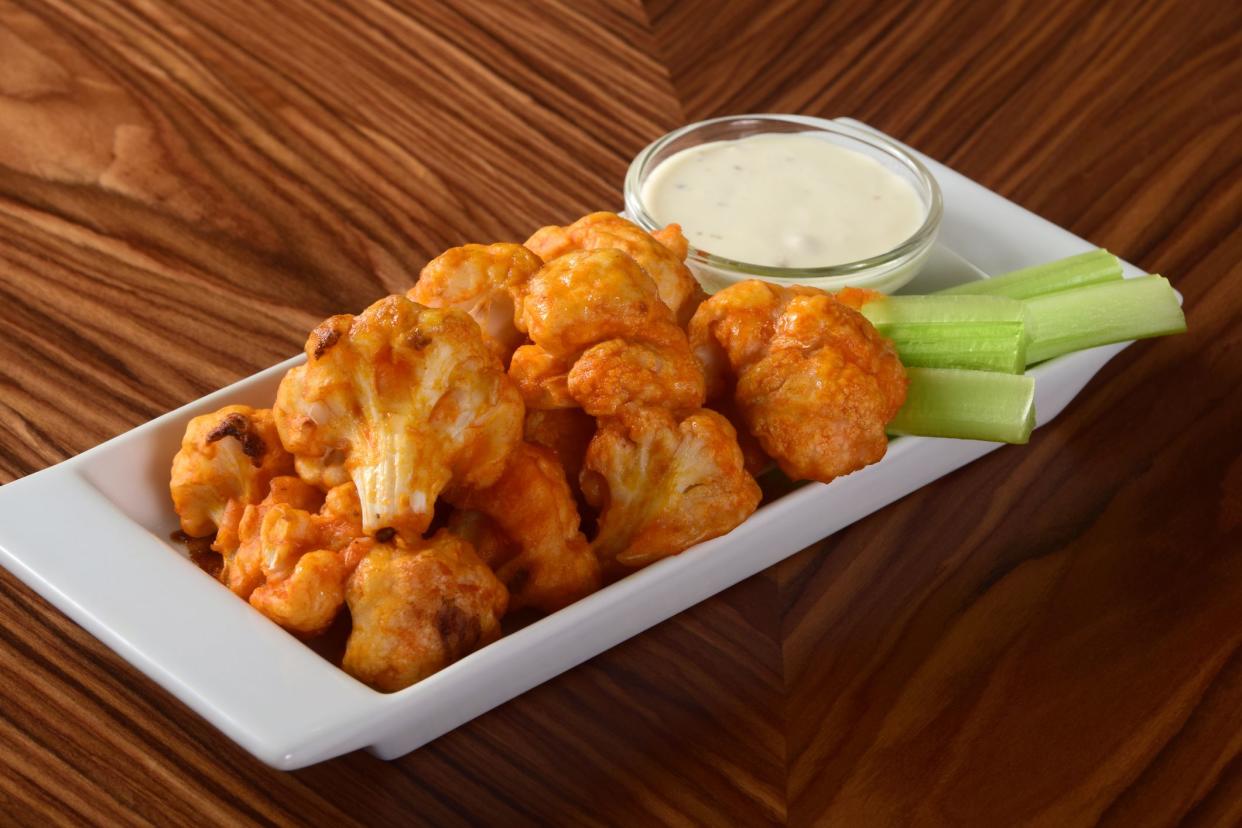 A vegetarian take on the classic Buffalo chicken wings - spicy baked cauliflower bites served with celery sticks and blue cheese dipping sauce.