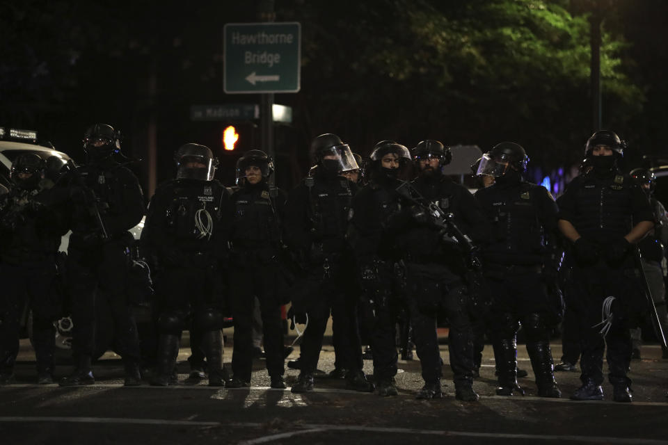 Portland Police line up to block from the street from protesters rallying at the Mark O. Hatfield United States Courthouse on Saturday, Sept. 26, 2020, in Portland, Ore. (AP Photo/Allison Dinner)