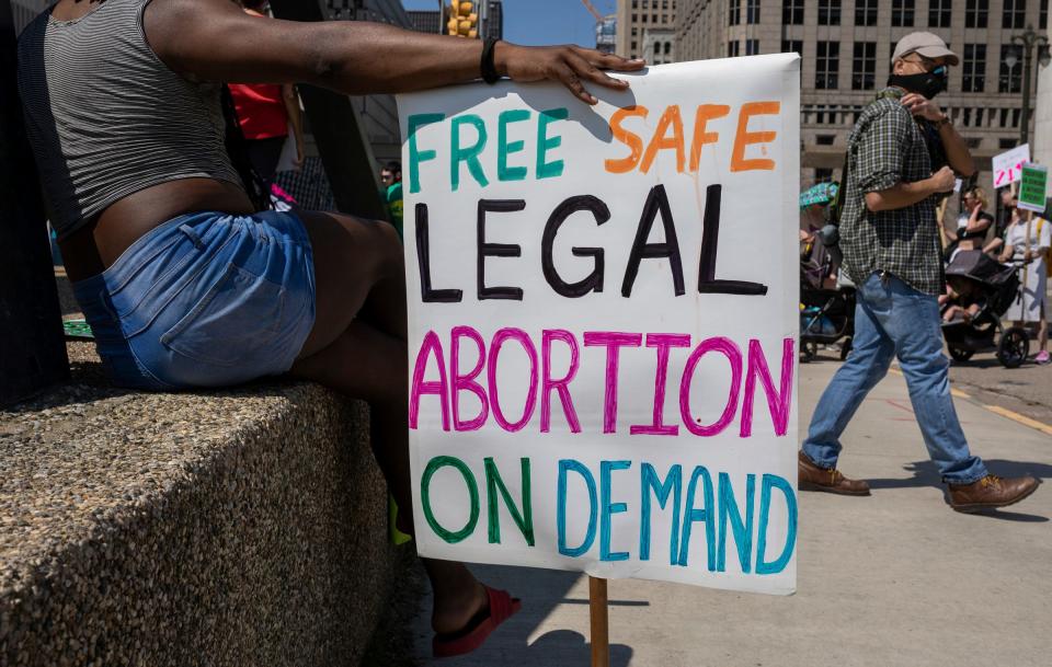 Topaz Crawford of Detroit holds a sign that reads 'Free Safe Legal Abortion on Demand' during a protest to protect abortion rights and the continuation of abortion medication at Hart Plaza in Detroit on Saturday, April 15, 2023.