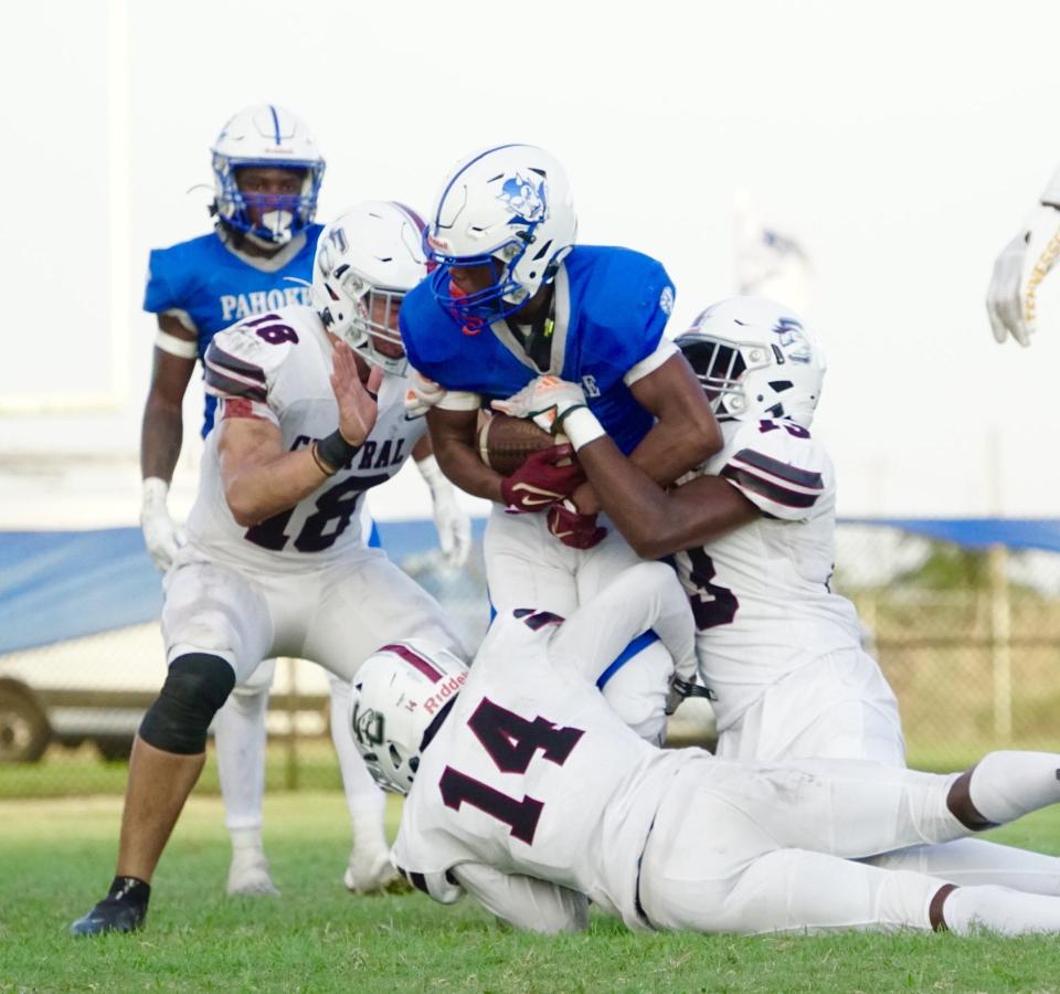Xavier Albert (14) and a group of Palm Beach Central defenders tackle a Pahokee ball carrier in a game on Thursday, Sept. 14, 2023 in Pahokee.