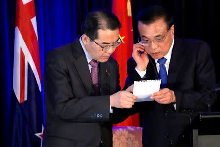 Chinese Premier Li Keqiang reads a note from an official during a media conference with New Zealand's Prime Minister Bill English in Wellington, New Zealand, March 27, 2017. REUTERS/Anthony Phelps