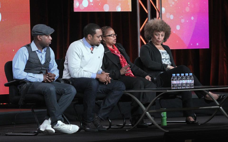 Shukree Tilghman (second from left) with musician Talib Kweli, filmmaker Sharon La Cruise and author/activist Angela Davis speak onstage during the Television Critics Association's Independent Lens Examines Black History Month panel in 2012.