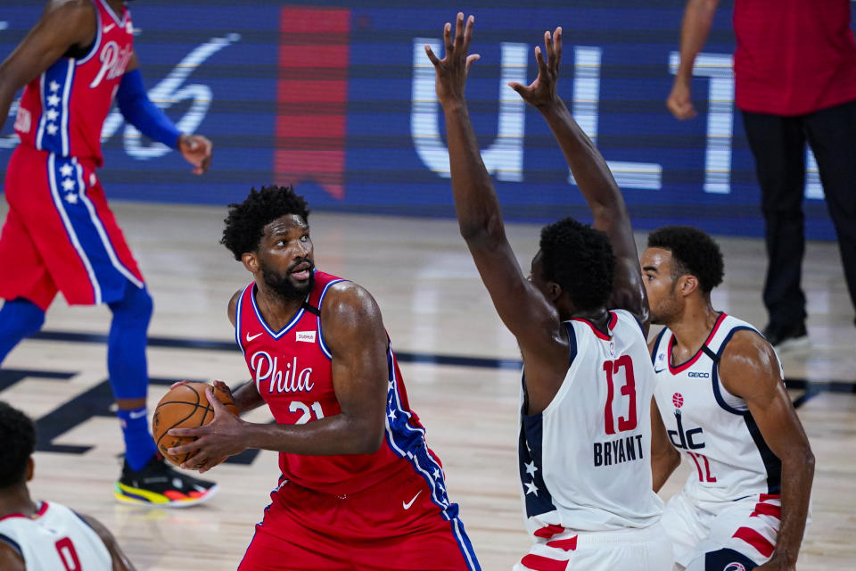 Philadelphia 76ers center Joel Embiid (21) looks to shoot over Washington Wizards center Thomas Bryant (13) during the second half of an NBA basketball game Wednesday, Aug. 5, 2020 in Lake Buena Vista, Fla. (AP Photo/Ashley Landis)