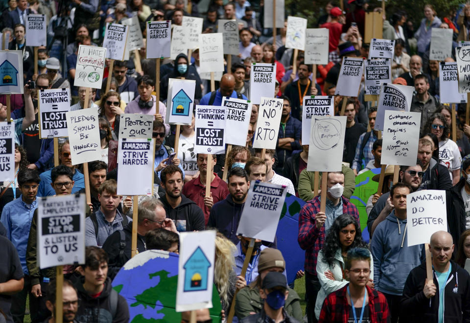 Amazon corporate workers hold picket signs while participating in a walkout to protest the company's return-to-office policies, Wednesday, May 31, 2023, in Seattle. Organizers called attention to the climate impact of commutes, saying it runs counter to the company's "Climate Pledge" to be carbon neutral by the year 2040, as well as concerns about recent layoffs. (AP Photo/Lindsey Wasson)