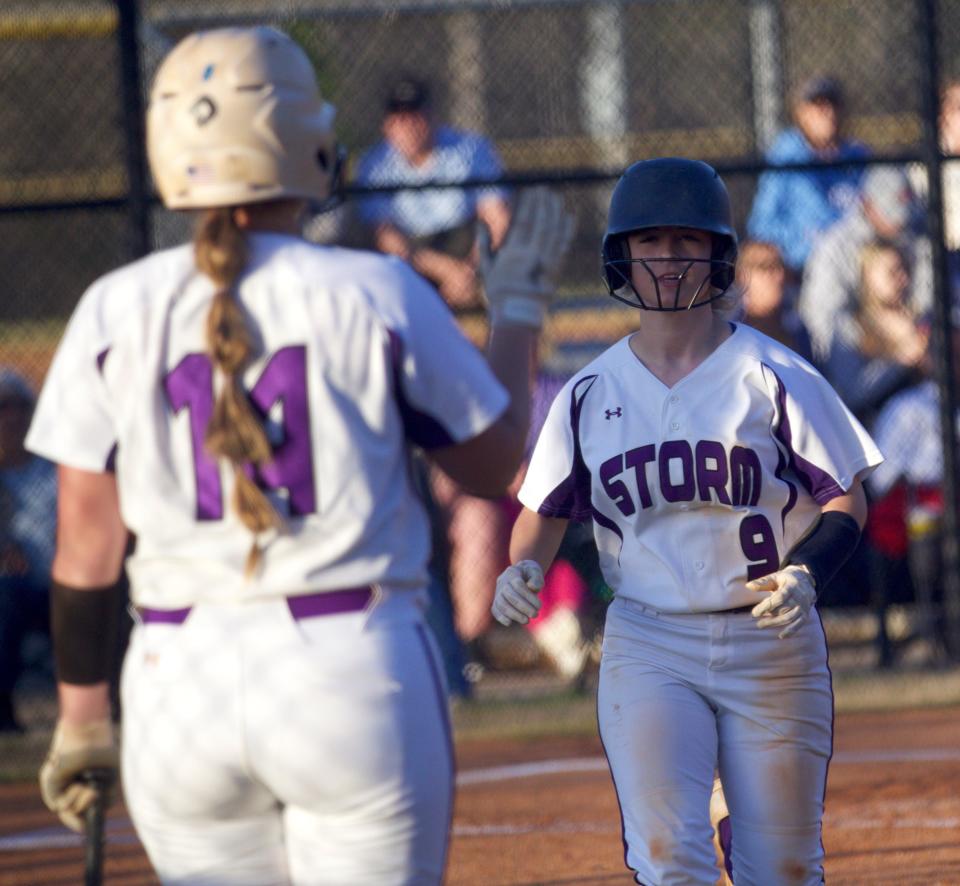 Stuart Cramer's Emma Donaldson raises her hand to congratulate Braley Hamilton after scoring what proved to be the game-winning run against North Gaston on April 1, 2022.