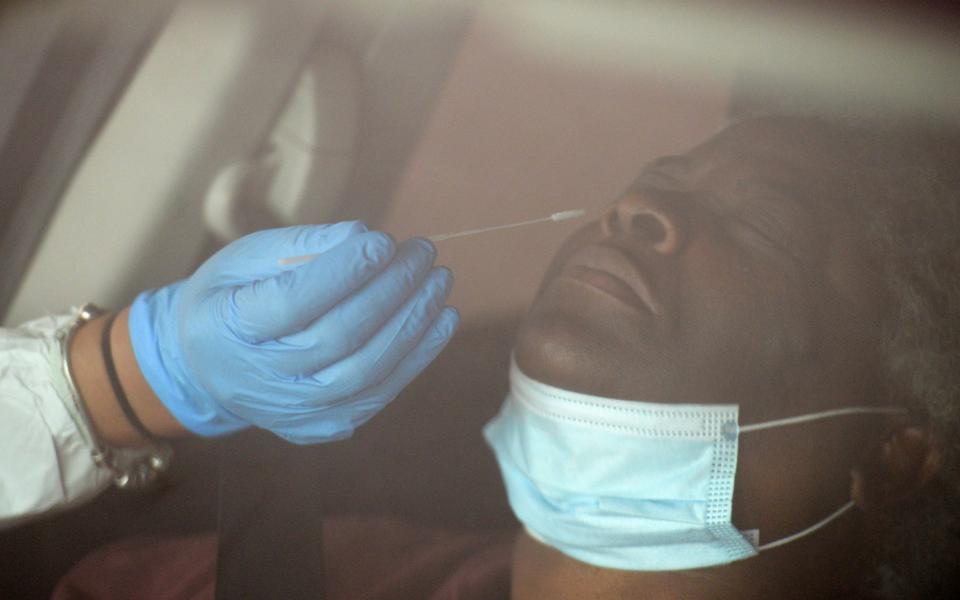 A medical worker administers a test for Covid-19 at a facility in Texas - Reuters