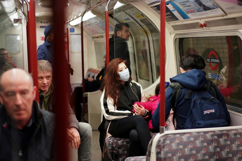 A woman wears a protective face mask on the London Underground in central London