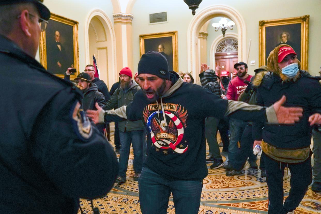 File: Trump supporters, including Doug Jensen, centre, confront US Capitol police in the hallway outside of the Senate chamber at the Capitol  (AP)