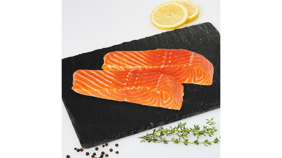 A photo of two salmon fillet on a board.