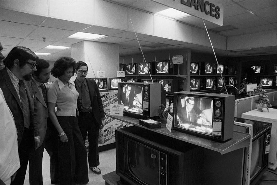 Customers and employees in the television section of a New York, N.Y., department store watch the open preliminaries of the special Senate committee hearing on the bugging of the Democratic headquarters in the Watergate, May 17, 1973.<span class="copyright">Bettmann Archive</span>
