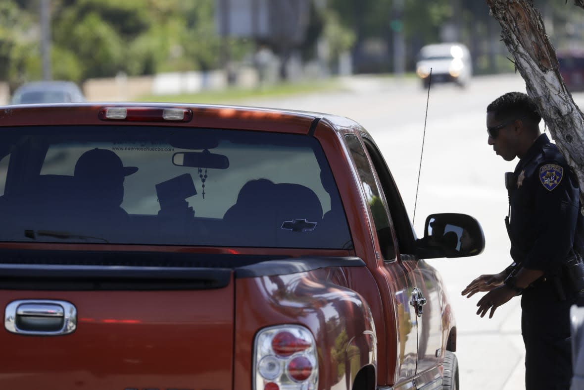 A California Highway Patrol officer stops a motorist who was suspected of speeding along Interstate 5 freeway on April 23, 2020, in Anaheim, Calif. (AP Photo/Chris Carlson, File)