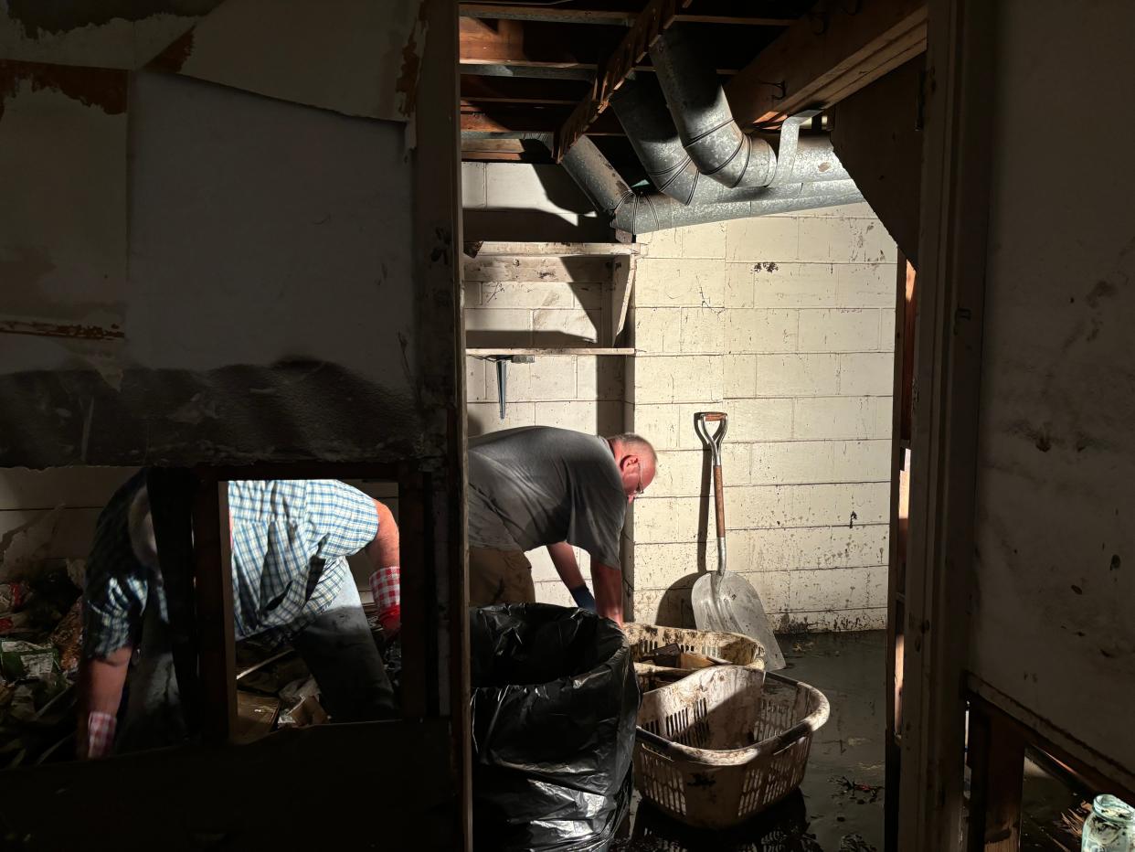 Jeff Knudtson helps Leonard Rust clean his basement in Spencer June 27, 2024, after historic flooding hit the city over the weekend.