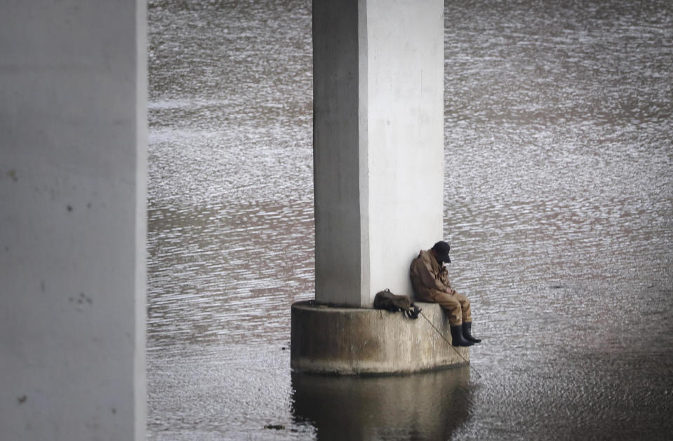 A man sits under a highway with his fishing rod on the Taedong River Monday, April 17, 2017, in Pyongyang, North Korea. Tensions have spiked in recent weeks over North Korea's advancing nuclear technology and missile arsenal. But in Pyongyang, where war would mean untold horrors, where neighborhoods could be reduced to rubble and tens of thousands of civilians could be killed, few people seem to care much at all. (AP Photo/Wong Maye-E)