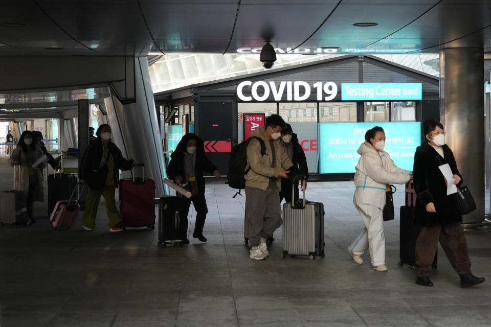 Passengers arriving from China pass by a COVID-19 testing center at the Incheon International Airport In Incheon, South Korea, Tuesday, Jan. 10, 2023. Chinese embassies stopped issuing new visas for South Koreans and Japanese on Tuesday in apparent retaliation for COVID-19 measures recently imposed by those countries on travelers from China. (AP Photo/Ahn Young-joon)