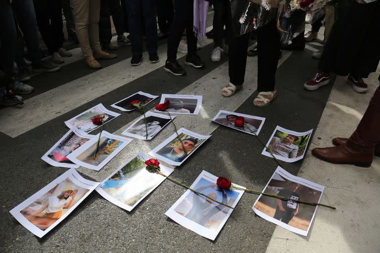 Imágenes y rosas rojas de los asesinados en Irán durante las protestas por la muerte de Masha Amini, frente a la embajada de Irán, a 28 de septiembre de 2022, en Madrid (España)
